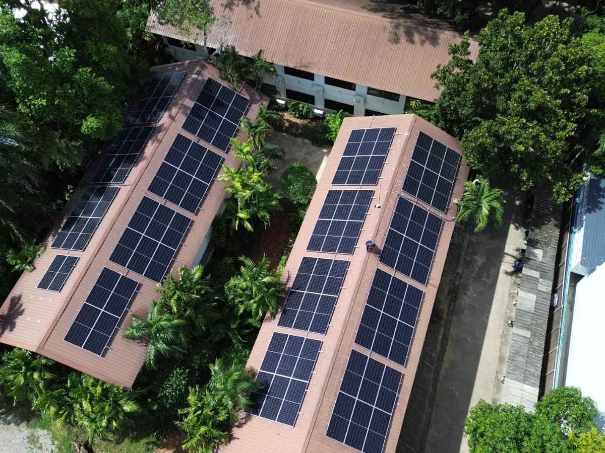 Solar arrays on several building roofs, seen from the air