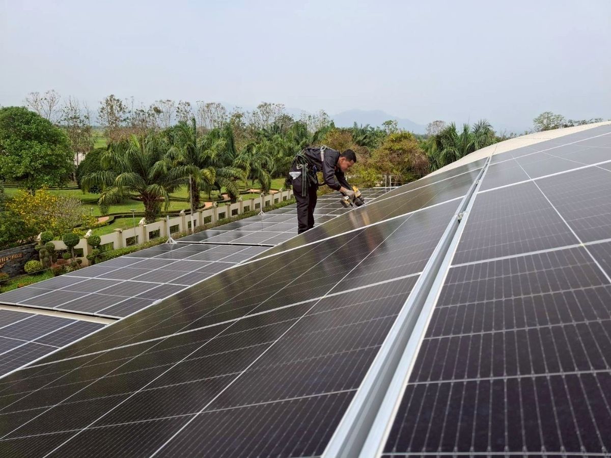 Technician working on a rooftop solar array